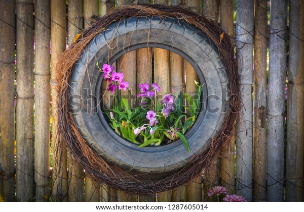 Vertical garden with\
tyre with flower\
plants