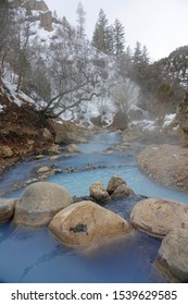 VERTICAL: Gorgeous Light Blue Spring Water Cascades From One Pond To Another In The Famous Diamond Fork Hot Springs In Utah. Spectacular Shot Of Steam Rising From Hot Springs In The Snowy Wilderness.