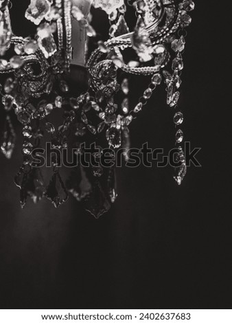 A vertical greyscale shot of the details of a gorgeous chandelier