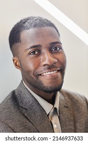 Vertical Headshot Of Young Black Entrepreneur With Genuine Smile Against Graphic Background