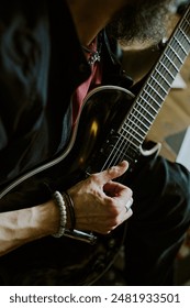 Vertical high angle view medium closeup of unrecognizable rock musician practicing guitar playing