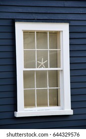 Vertical Image Of Beachfront Window With Starfish Set In One Of It's Panes.