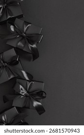 Vertical image of black gift boxes tied with a satin ribbon on a black background, conveying the festive spirit of Black Friday.