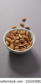 Vertical Image Of A Bowl Of Almonds On A Lilac Background. Healthy Snack Food, Diet And Nutrition.