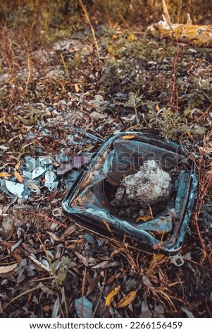 Vertical image of broken crashed smashed to smithereens old vintage dead retro TV set trashed screen antique television with stone rock
