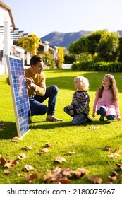 Vertical Image Of Caucasian Father Showing Solar Panel To Children. Family, Green Energy, Eco Awareness And Spending Quality Time Together Concept.