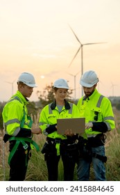 Vertical image group of technician workers man and woman work using laptop and stay in front of windmill or wind turbine with evening light.