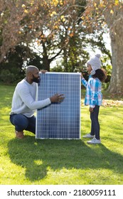 Vertical Image Of Happy African American Father Showing Solar Panels To Daughter. Family, Green Energy And Eco Awareness Concept.