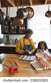 Vertical Image Of Happy African American Grandmother And Granddaughter Baking In Kitchen. Family And Spending Quality Time Together Concept.