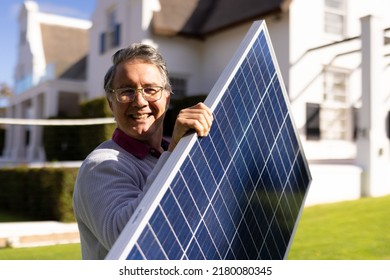 Vertical image of happy caucasian senior man with solar panel in garden. Green energy, eco awareness and technology concept. - Powered by Shutterstock