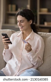 Vertical Image Joyful Beautiful Young Hispanic Woman Making Payments In Mobile Shopping Application Using Bank Credit Card, Buying Goods In Internet Store, Enjoying Purchasing Services Online.