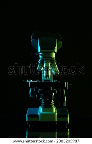Vertical image of laboratory microscope and copy space on black background. Laboratory, science, research and chemistry concept.