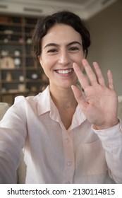 Vertical image mobile web camera view smiling young attractive Hispanic woman waving hand, streaming stories online in social networks, vlogging recording selfie video, starting distant conversation. - Shutterstock ID 2130114815