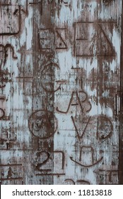 Vertical Image Of An Old Door Covered In Western Branding Iron Marks