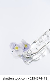 Vertical Image Of Pipette With Transparent Liquid On Light Glass Background With Copy Space. Texture Of Face Serum Or Cosmetic Oil. Selective Focus, Macro Photo