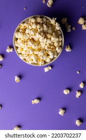 Vertical Image Of Pop Corn In Bowl Lying On Violet Background. Food, Snacks, Cinema And American Cuisine Concept.