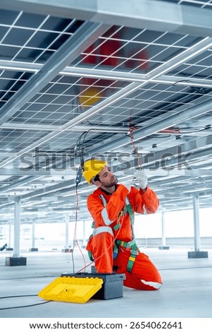 Vertical image of professional technician worker or engineer use tools for maintenance or check system under solarcell panel.