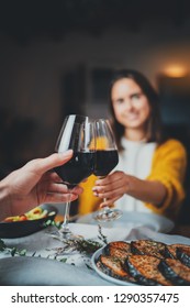 Vertical Image Of Romantic Couple Making Cheers With Glasses Of Red Wine, Young Sweet Couple Dining At Night In Cozy Restaurant With Healthy Food, Celebration Cheers Dinner Love Concept