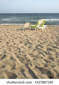 Vertical Image Of A Sandy Beach With Two Beach Chairs Looking At The Sea.Texture Of The Sand,copy Space, Text Space,web Context.