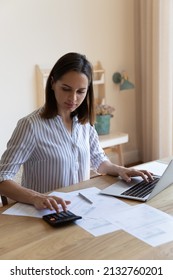Vertical image serious housewife sit at table at home kitchen check household bills, make calculations on calculator, pay utilities through e-banking system on laptop. Manage family finances concept - Shutterstock ID 2132760201