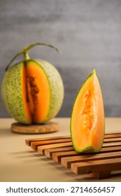 Vertical image of sliced melon on a brown table.