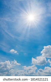 Vertical Image Of Sun On Blue Sky With Sunbeams And Clouds In The Day