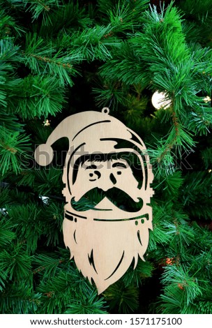 Vertical Image of a Wooden Santa Claus Ornament Hanging on Christmas tree