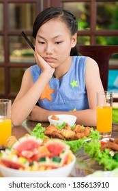 Vertical Image Of A Young Girl Being Bored At The Family Dinner