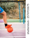 vertical latina woman soccer player stepping on a ball with one leg on a football field in bolivia - football concept