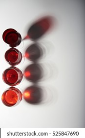 Vertical Line Of Red Wine Glasses With Stems Isolated On White Background View From Top