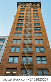 Vertical lines and functionality blend in the design of a classic brick building with an external fire escape.