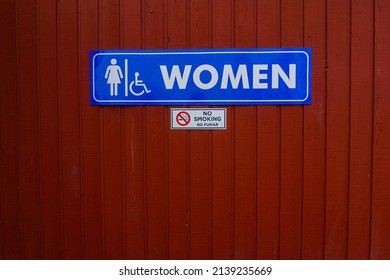 Vertical lines painted red boards in a pattern forming a texture with Women Bathroom sign on top. - Powered by Shutterstock