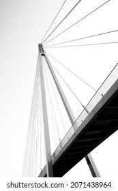 A vertical low angle closeup view of a road welded metal cable-stayed bridge on a white background