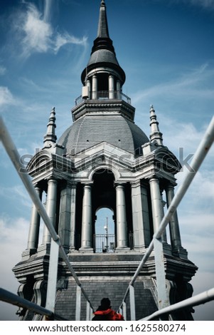 A vertical low angle shot of a building with a steeple in Roubaix, France