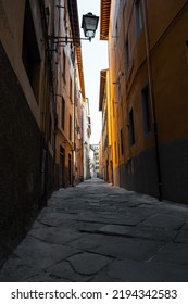 A Vertical Low Angle Shot Of Cobblestone Alley Between Buildings