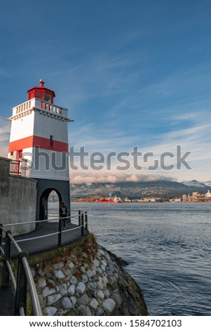A vertical low angle shot of the Lighthouse on Seawall in Stanley Park, Vancouver