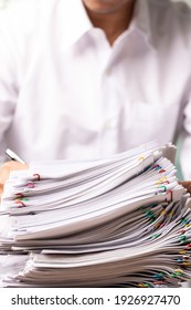 Vertical Male Office Workers With White Shirt Holding And Writing Documents On Office Desk, Stack Of Business Overload Paper.