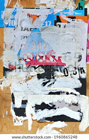 Vertical Old Wall Background With Torn Posters, Stickers and Advert. Old Grunge Ripped Torn Vintage Posters and Ads Background Texture.