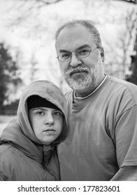 Vertical Orientation Black And White Image Of A Boy With Autism And Down's Syndrome And His Father On A Winter Day / Parenting A Child With Autism