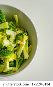 Vertical Overhead View Photo Of Cooked Broccoli In White Bowl