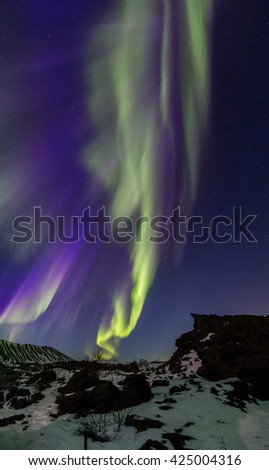Vertical Panoramic Northern Lights bursting above an Arctic rocky landscape