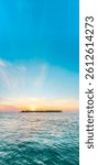 Vertical panoramic photo of sunset starting behind a tropical island in Key West, Florida.
