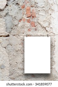Vertical paper sheet frame hung by clothes pin on grey cracked and scratched concrete wall background