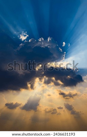 VERTICAL PHOTO Beautiful light Sun shines behind the cumulus clouds.Colorful sunrise with Clouds over hill.Sun hiding behind a cloud on the day sky.Sunray with dark Clouds sunset.