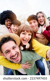 Vertical Photo Of Cheerful Group Of Happy Friends Taking Smiling Selfie In Piggyback. Three Couple Having Fun Together Outdoors At Park In The City. People Enjoying Travel In Vacation Holidays.