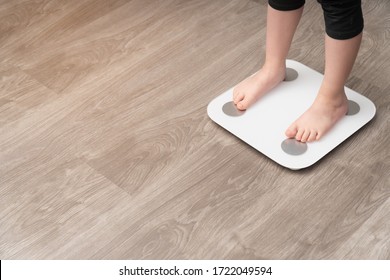 Vertical Photo Closeup Of Baby's Legs On A Measuring Scale. Childhood Obesity Control Concept, Side View.