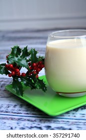 Vertical Photo Of Egg Nog And A Holly Leaf On A Green Plate With A Wooden Background/Egg Nog Holly Leaf/Christmas Drink