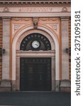 Vertical photo of entrance to old main train station in Belgrade, Serbia with clock and year of building 1884 written with roman numbers above it
