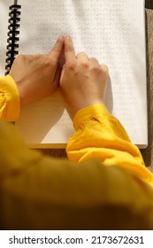 Vertical Photo. Female Hands With Yellow Sleeves On A Book In Louis Braille Font. Woman Is Reading Book For Blind. January 4 . International Day Of Visual Impairment. WHO