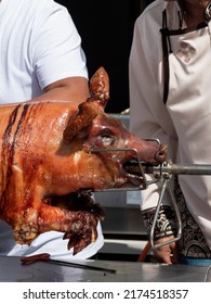 Vertical photo of a grilled suckling pig on a spit